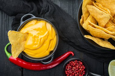 Peynir soslu tortilla cipsi, siyah ahşap zemin, üst ya da düz yatar