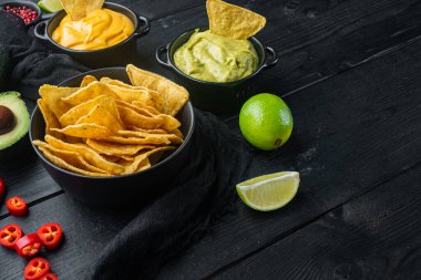 Üçgen sarı mısır tortilla soslu, siyah ahşap arka planda metin için kopyalama alanı olan.