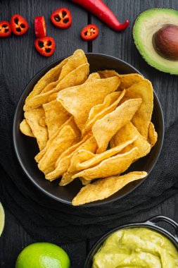 Nachos mısır cipsi geleneksel sos seti, siyah ahşap arka plan, üst görünüm veya düz yatıyordu