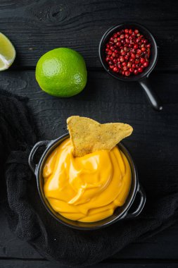 Peynir soslu kase, nacho, siyah ahşap arka plan, üst ya da düz.
