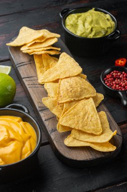 Nacho, guacamole ve peynir sosu, eski ahşap masada.