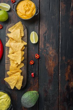 Üçgen sarı mısır tortilla parçacıklı sos, eski ahşap masa, üst görünüm veya düz metin alanı ile yatar