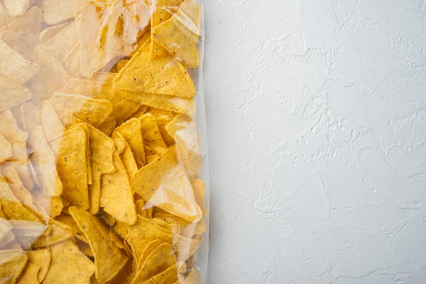 Tortilla Mexican nachos  chips in plastic  bag, on white background, top view or flat lay with copy space for text
