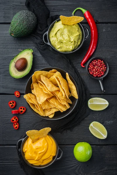 Üçgen sarı mısır tortilla soslu, siyah ahşap arka planda, üst ya da düz yatar