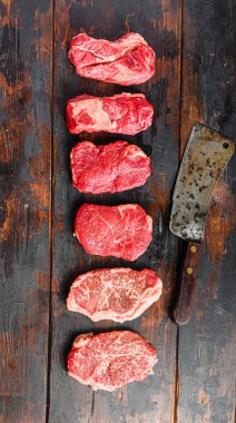 Bir dizi çiğ biftek: üst bıçak, kıç, Chuck göz devirme eski ahşap arka plan görünümlü kasap satır ile