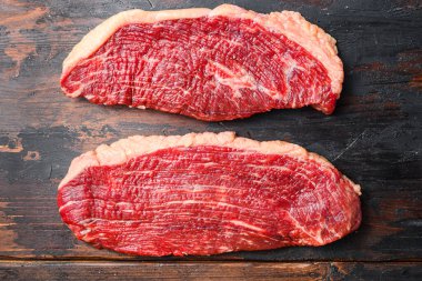 Bir çift organik picanha bifteği, koyu eski ahşap arka plan, üst manzara