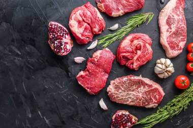 Alternatif çiğ biftek dilimleri üst bıçak, chuck roll ve kıç biftek, otlar ve nar üst görünümü ile, metin için yer