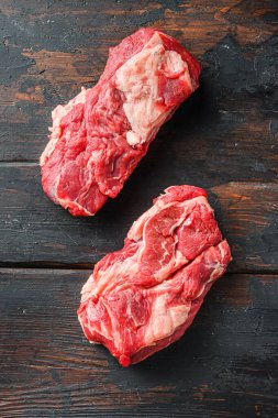 Taze çiğ biftek. Eski siyah ahşap masanın üstünde Chuck 'ın gözleri yuvarlanıyor..