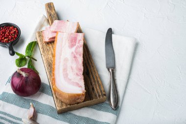 Pastırma pancetta, beyaz arka planda kesilmiş ve kesilmiş otlar ve metin için yer var..