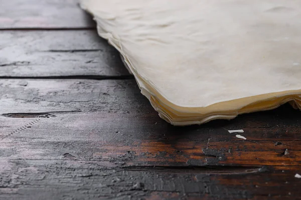 Filo dough for cooking  over old dark wooden table side view