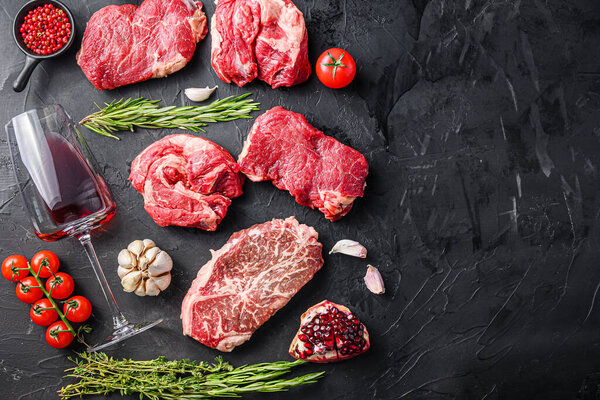 Alternative beef cut set with herbs and red wine glass, top view with space for text