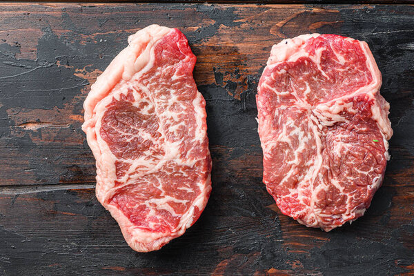 Top blade organic meat cut, raw marbled beef steak,  On dark wooden background, top view