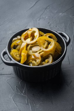 Kavanozda dilimlenmiş Jalapeno Biberleri, siyah arka planda.