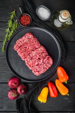 Organik Çiğ Çimen Fed, Ground Beef, siyah ahşap masa arkaplanı, üst görünüm düz yatıyordu