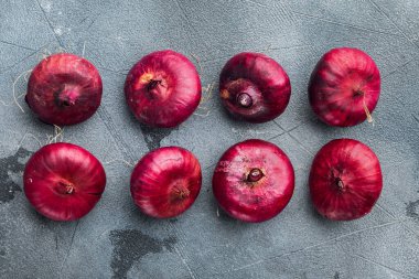 Kırmızı soğan, gri arkaplanda, üst görünüm düz yerde.