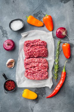 Kıyma. Gri arkaplanlı, düz manzaralı, içinde yemek malzemeleri olan yer eti.