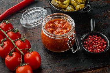 Meksika salsa sosu kavanozu, eski siyah ahşap masa arkasında.