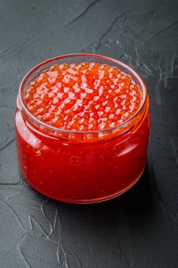 Kırmızı havyar kavanozu, siyah arka planda.