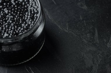 Siyah arkaplanda cam havyar kavanozu, metin için kopyalama alanı