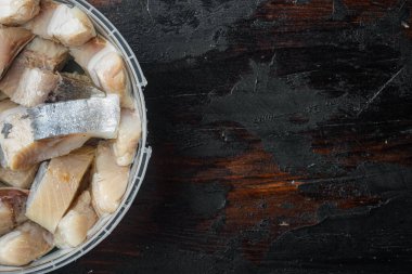 Yağ ile ıslanmış ringa parçaları, eski koyu ahşap masa arkaplanı, üst görünüm düz metin alanı için fotokopi alanı yatıyordu