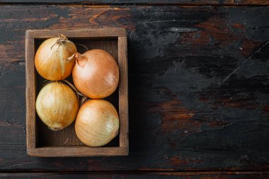 Taze soğanlar, eski koyu ahşap masa zemininde, üst görünüm düz metin için kopyalama alanı ile yatıyordu