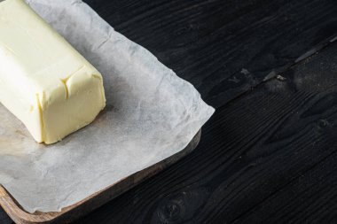 Taze tereyağı paketi, siyah ahşap masa zemininde metin için kopyalama alanı ile