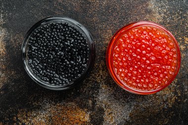 Siyah ve kırmızı havyarlı cam kavanoz, eski koyu kırsal arka planda, üst manzara düz