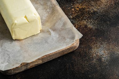 Bir parça taze tereyağı, eski koyu kırsal arkaplan üzerinde metin için kopyalama alanı ile