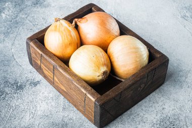 Gri arkaplanda organik soğanlar.