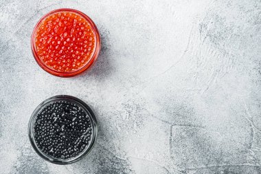 Siyah ve kırmızı havyarlı cam kavanoz, gri arkaplan, üst görünüm düz metin için metin alanı ile yatıyordu