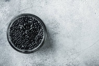 Gri arkaplanda cam havyar kavanozu, üst görünüm düz metin için metin alanı ile yatıyordu