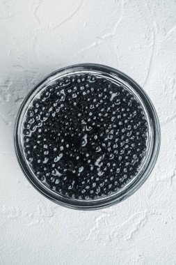 Siyah mersin balığı havyarı kavanozu, beyaz arka planda, üst manzara düz.