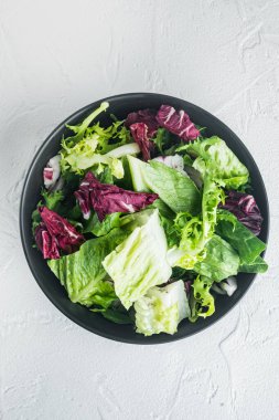Karışık salata salatalı kaseler taze marul yaprakları, beyaz arka planda, üst manzara düz.