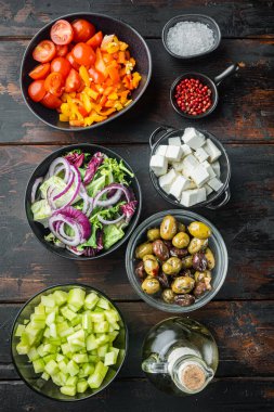 Yunan salatasının ana malzemeleri: taze zeytin karışımı, feta peyniri, domates biberi, eski koyu ahşap masa arkaplanı, üst düz görünüm