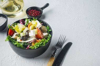 Beyaz arka planda taze sebzeli, feta ve zeytinli geleneksel Yunan salatası ve metin için kopya alanı