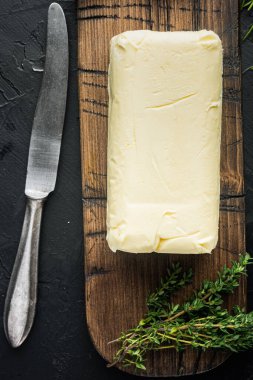 Taze tereyağı paketi, siyah arkaplanda, üst görünüm düz yatıyordu