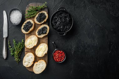 Siyah mersin balığı havyarlı kanepe, siyah arkaplan, üst görünüm düz metin için metin alanı ile yatıyordu