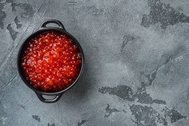 Lezzetli kırmızı havyarlı kase, gri arkaplan, üst görünüm düz metin için kopya alanı ile yatar