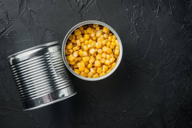 Kutuda konserve mısır, siyah arkaplan, üst görünüm düz metin için kopyalama alanı ile yatıyordu