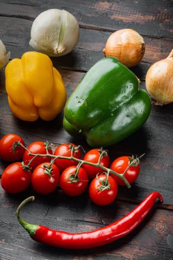 Sebze koleksiyonu. Çan biberi ve soğan. Eski, siyah ahşap masa arkasında.