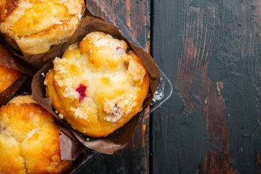 Taze pişmiş çörekler kabın içinde, eski koyu ahşap masa arkaplanı üzerinde, üst görünüm düz metin alanı için fotokopi alanı ile yatıyordu