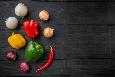 Sebze toplama Biber ve soğan, siyah ahşap masa arkaplanı, üst görünüm düz metin alanı için fotokopi alanı ile yatıyordu