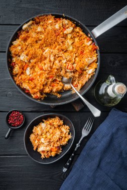 Tavuk enchiladas, Güveçte servis, siyah ahşap masa arka planı, üst görünüm düz yatıyordu