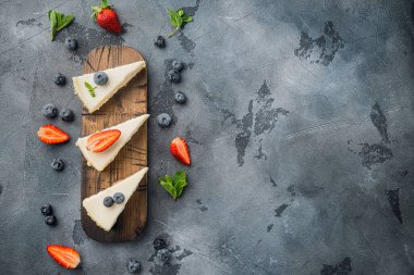 Klasik New York Cheesecake, dilimlenmiş, gri arkaplan üzerinde, üst görünüm düz metin alanı için kopyalanmış