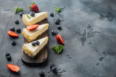 Klasik New York Cheesecake Dilimleri, metin için kopya alanı ile gri arkaplan üzerinde