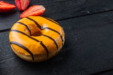 Turuncu Donut, siyah ahşap masa arkaplanında metin için kopyalama alanı ile