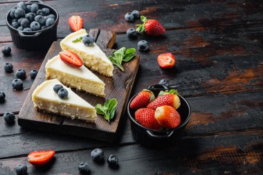 Taze berrie ile ev yapımı cheesecake, eski koyu ahşap masa zemininde metin için fotokopi alanı ile