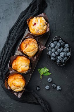 Taze berrie 'li yabanmersinli kekler, siyah arka planda, en üstteki düz yerde.