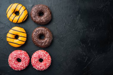 Siyah zemin üzerinde lezzetli jöleli çörekler, üst görünüm düz metin için metin alanı ile yatıyordu