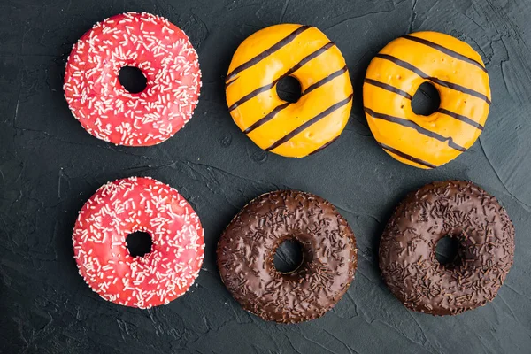 Varios Donuts Decorados Sobre Fondo Negro Vista Superior Plano Laico — Foto de Stock